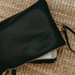 On the floor is a unisex black changing pouch packed with wipes & a change-mat.