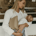 A new mum holds her baby boy with her nappy wallet tucked under her arm.