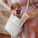 woman takes sunglasses out of protective pocket in a silver cross-body bag